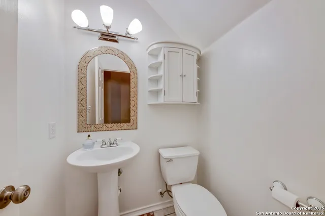 a bathroom with a toilet sink and mirror