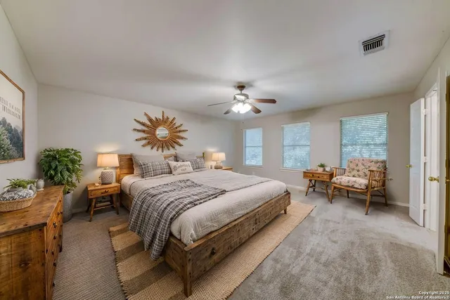 a spacious bedroom with a bed and a chandelier