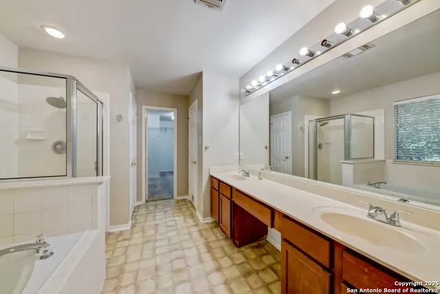 a spacious bathroom with a double vanity sink mirror and double