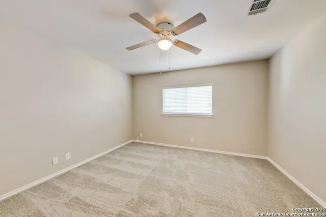 an empty room with a window and a ceiling fan