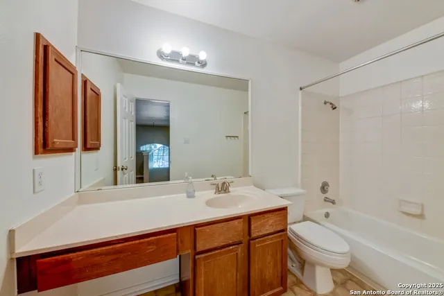 a bathroom with a sink a toilet a mirror and shower