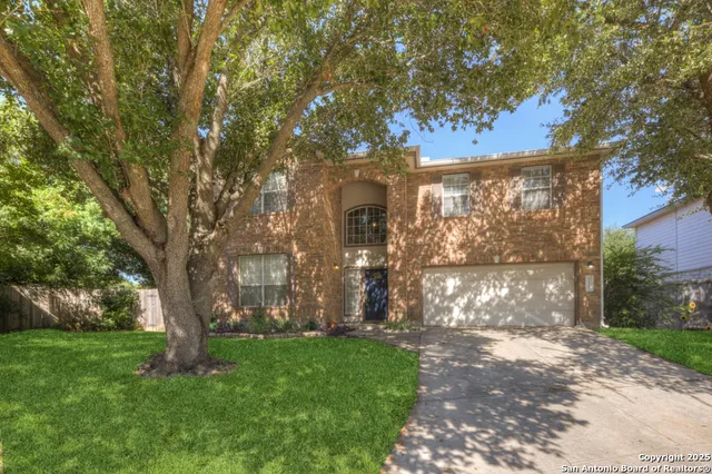 a front view of a house with a tree