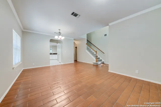 a view of empty room with wooden floor and window