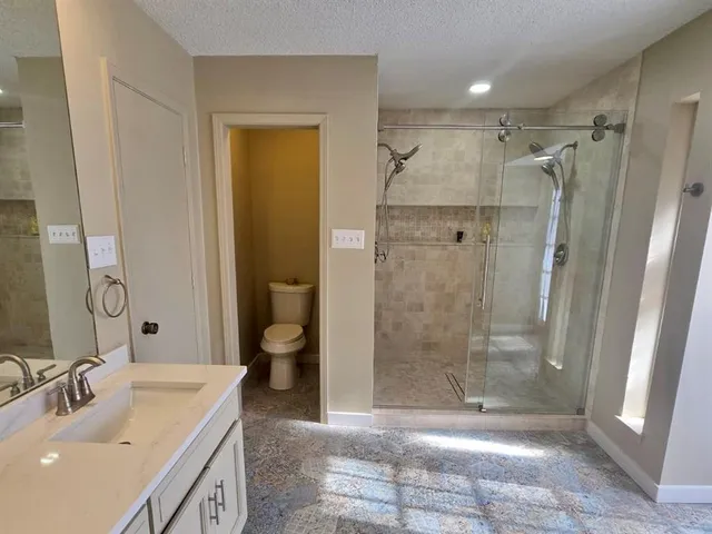 a bathroom with a shower sink and toilet