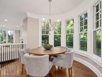 a large kitchen with kitchen island a island wooden floor and stainless steel appliances
