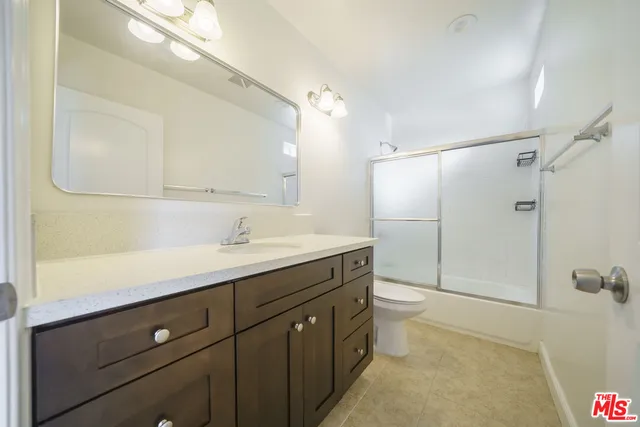 a spacious bathroom with a double vanity sink toilet and shower