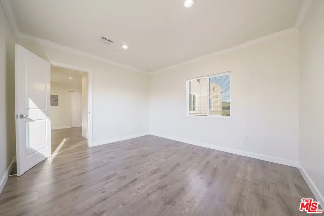 an empty room with wooden floor and a window