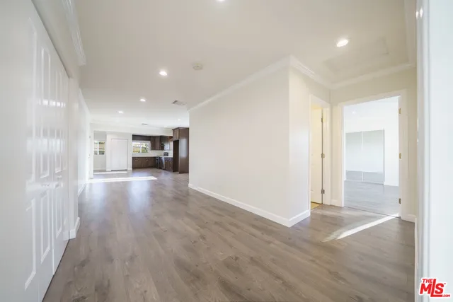 a view of empty room with wooden floor