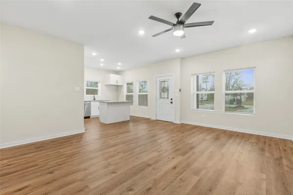 a view of a livingroom with a kitchen counter tops and a ceiling fan