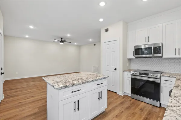 a kitchen with stainless steel appliances granite countertop a stove a sink and a refrigerator