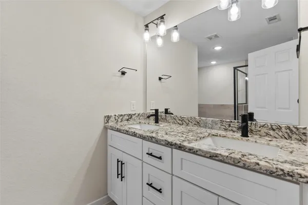 a bathroom with a granite countertop sink and a mirror