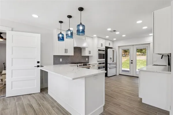 a kitchen with kitchen island a stove a sink and a refrigerator