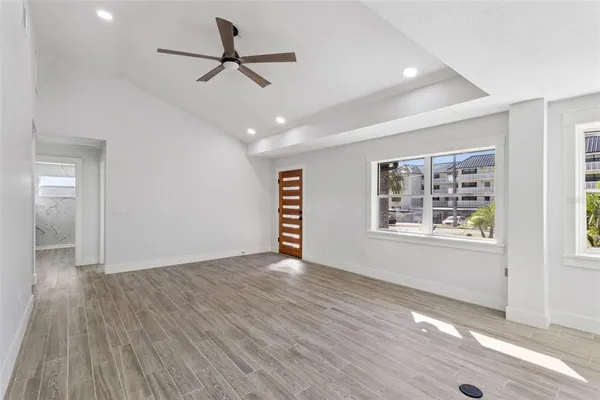 a view of an empty room with a window and wooden floor