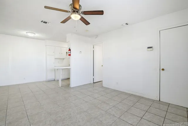 a view of a refrigerator in kitchen and white cabinets