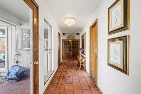 a view of a hallway with wooden floor and windows