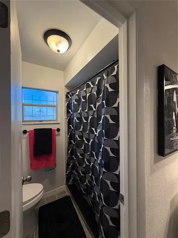 a bathroom with a toilet and a shower