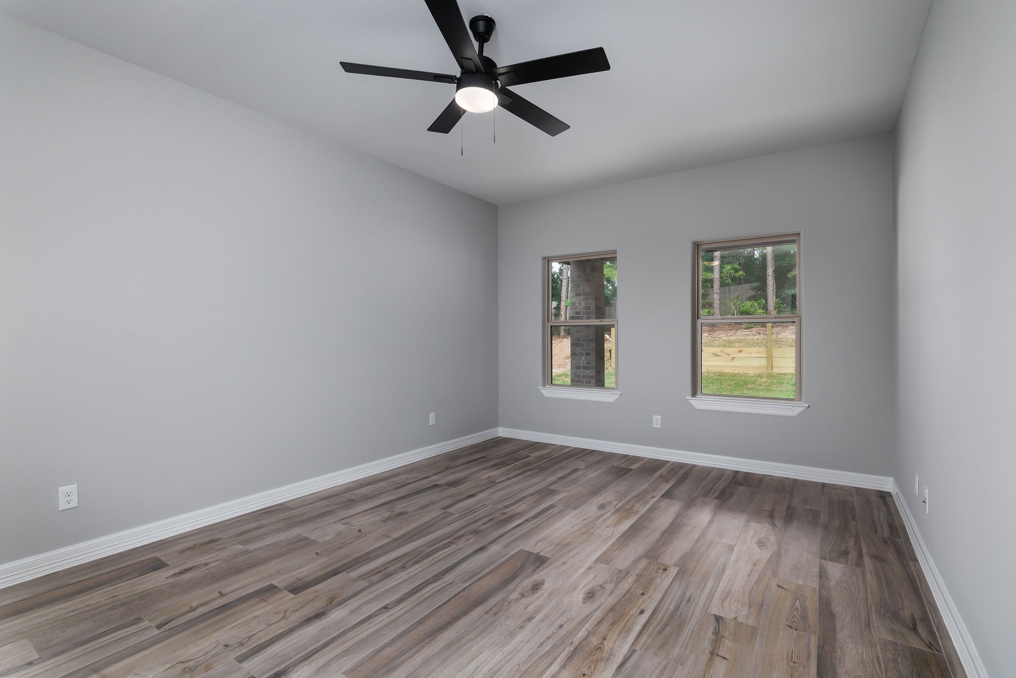 364 Dahlia Road Huntsville, TX 77320 - Photo 30 of 34 an empty room with wooden floor ceiling fan and windows
