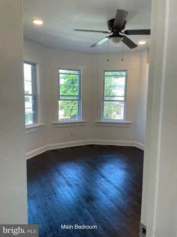 a view of an empty room window and wooden floor