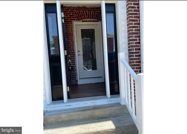 a view of a hallway with wooden floor and entryway