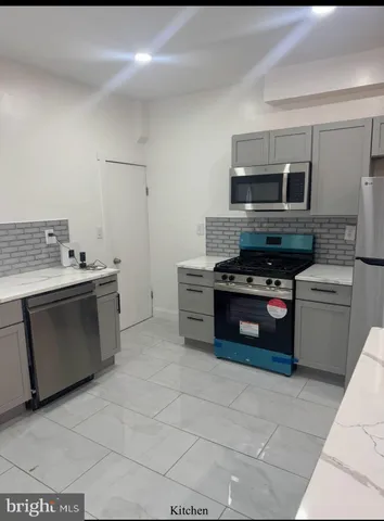 a kitchen with stainless steel appliances a stove a sink and a microwave