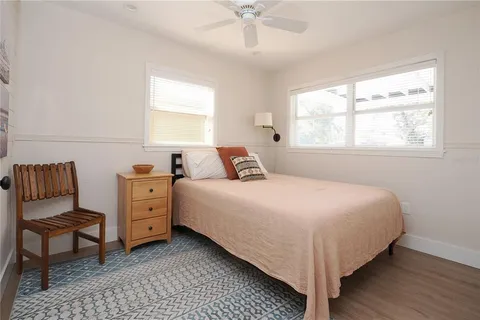 an empty room with wooden floor and a ceiling fan