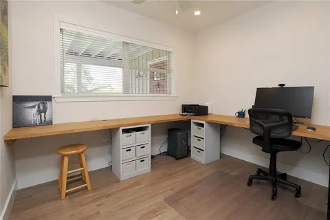 a view of an empty room with a window and a dresser