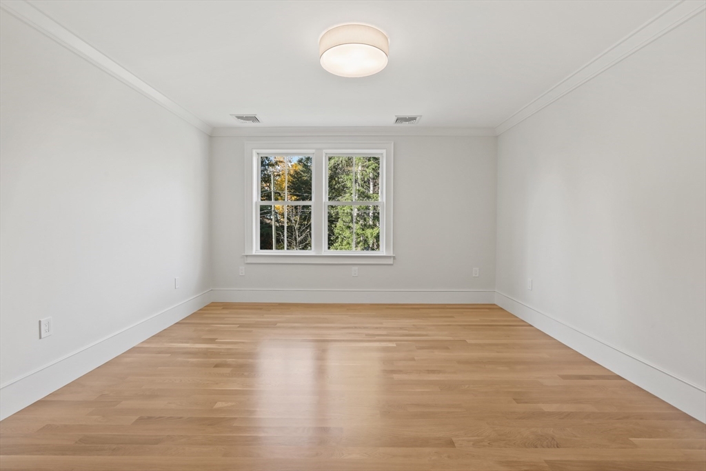 56 Sunset Rock Road Andover, MA 01810 - Photo 29 of 42 an empty room with wooden floor and windows