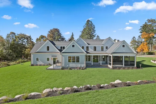 a front view of a house with a garden and trees