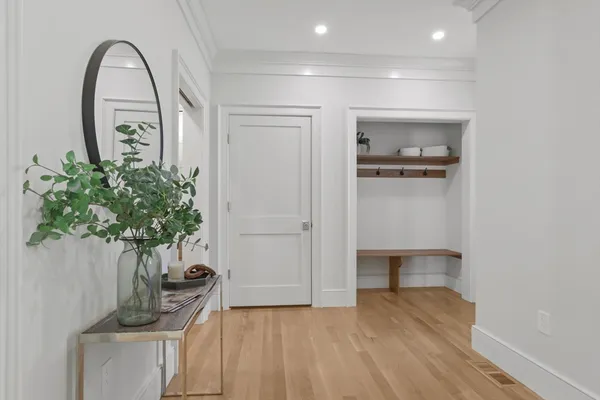 a view of a hallway with entryway wooden floor and front door