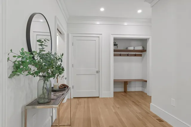 a view of a hallway with entryway wooden floor and front door