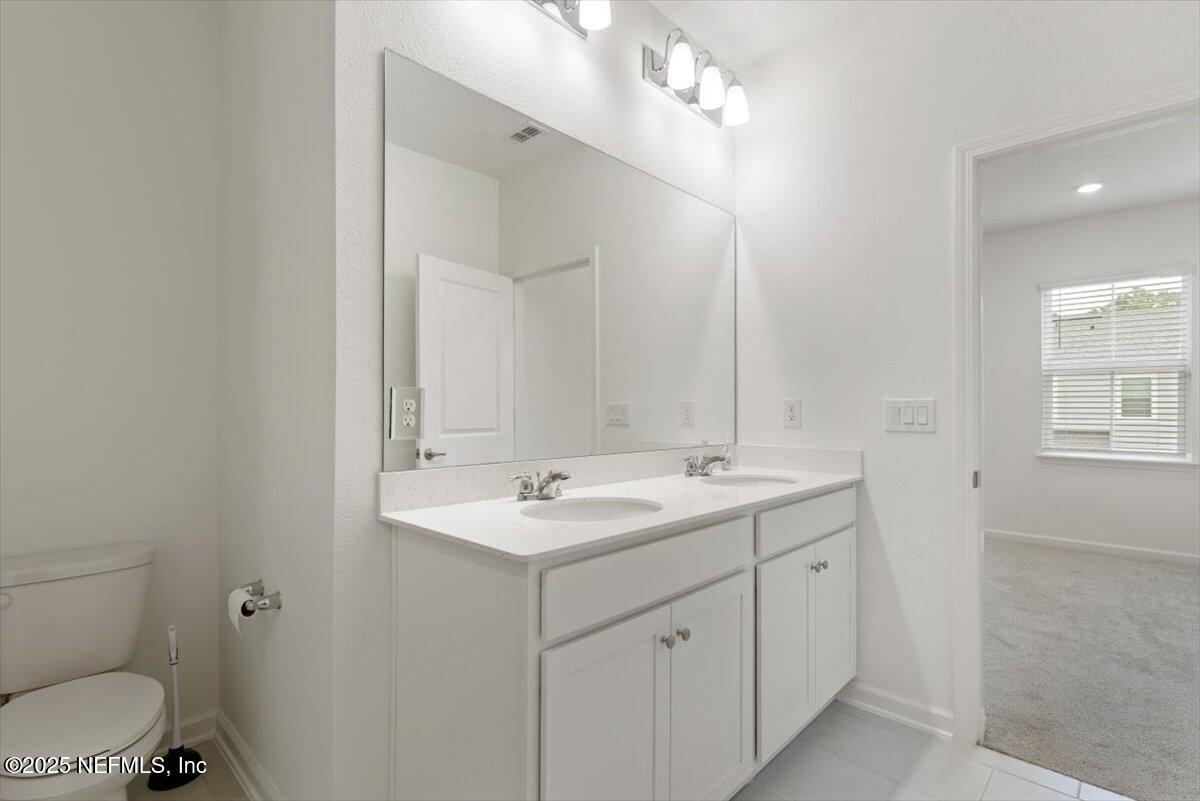 39 Thurnham Lane St. Augustine, FL 32092 - Photo 26 of 52 a bathroom with a toilet a sink and mirror