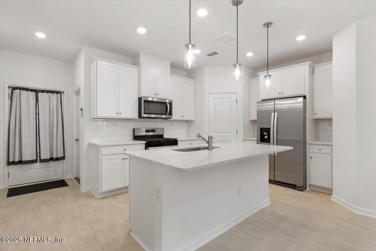 39 Thurnham Lane St. Augustine, FL 32092 - Photo 7 of 52 a kitchen with white cabinets and stainless steel appliances