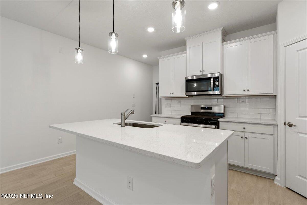 39 Thurnham Lane St. Augustine, FL 32092 - Photo 8 of 52 a kitchen with a sink a microwave a stove and refrigerator