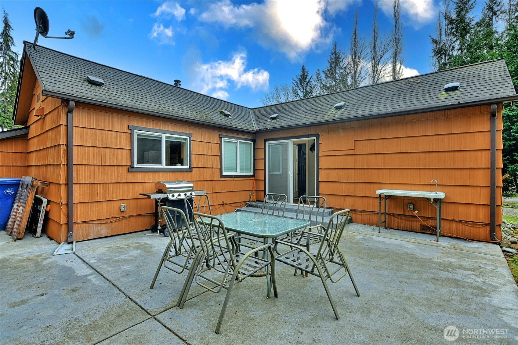15421 Jim Creek Road Arlington, WA 98223 - Photo 14 of 27 a backyard of a house with barbeque oven table and chairs