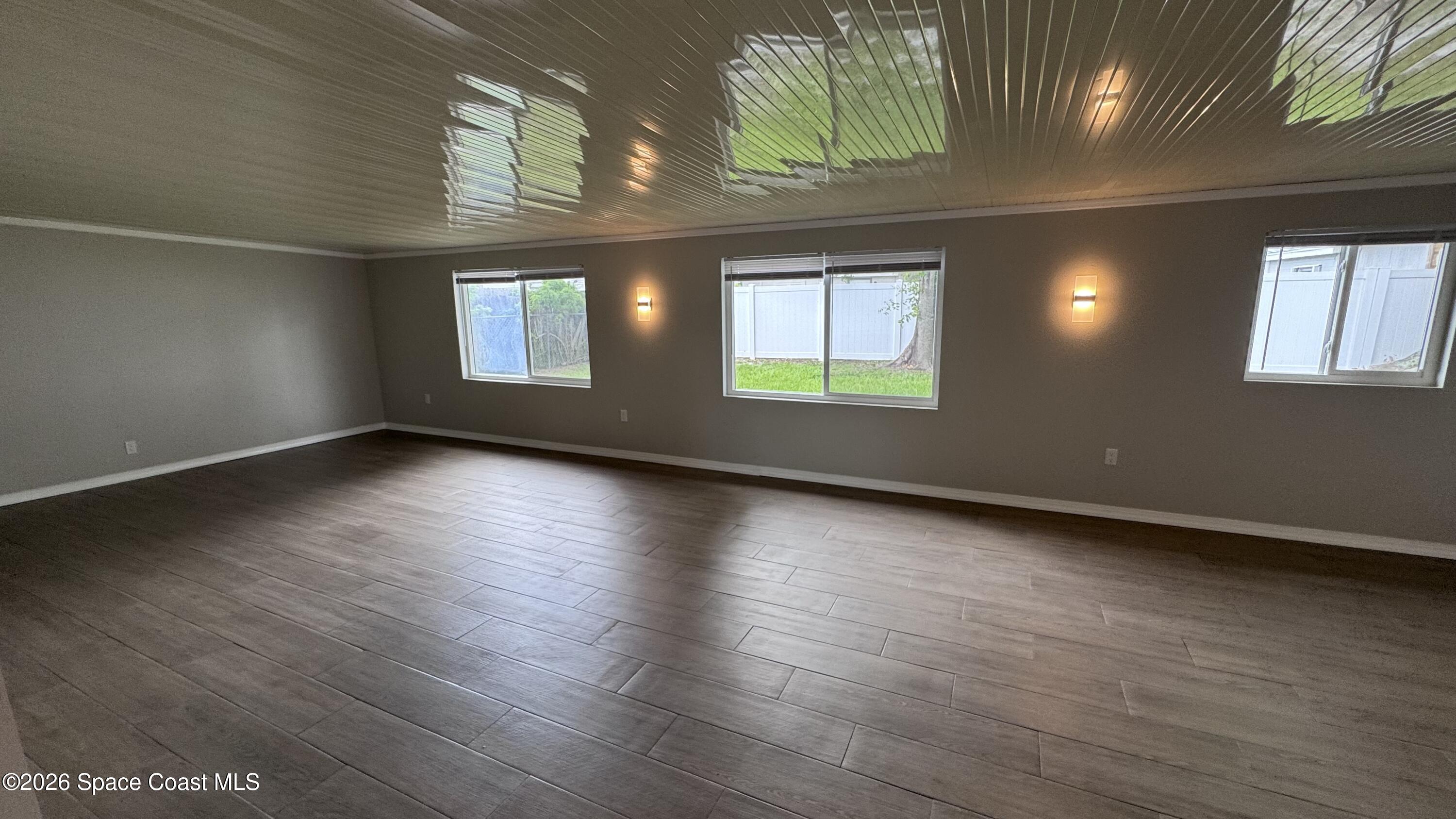2137 Laden Road Melbourne, FL 32935 - Photo 17 of 23 an empty room with wooden floor and windows