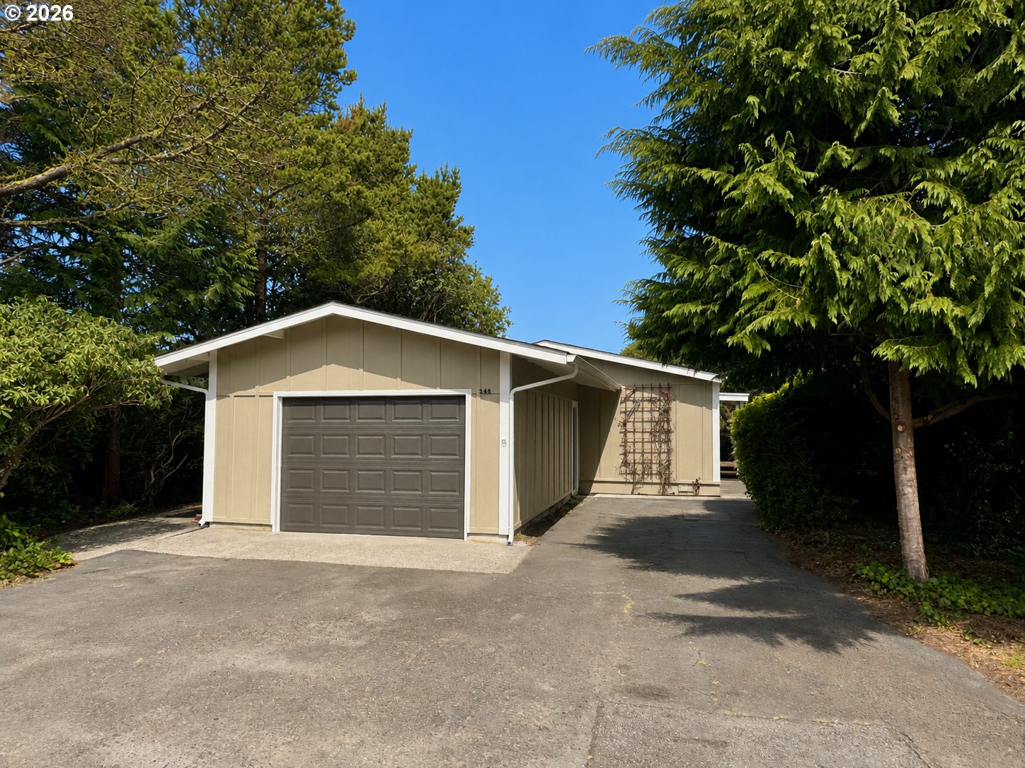 1600 Rhododendron Drive, Unit 245 Florence, OR 97439 - Photo 2 of 47 a front view of a house with a yard and garage