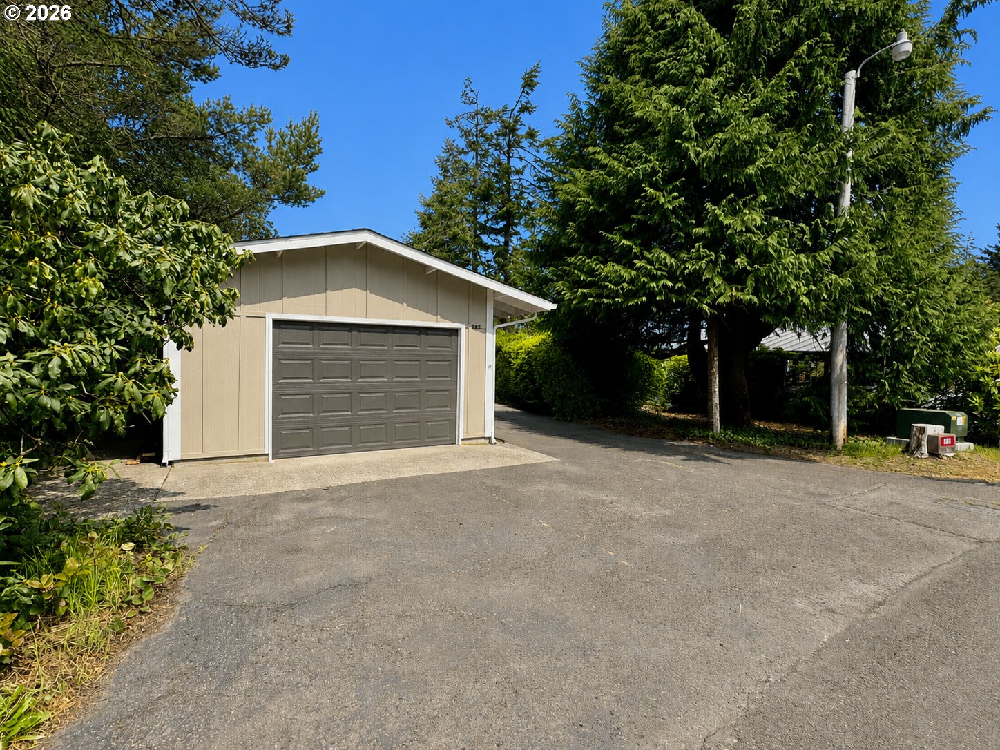 1600 Rhododendron Drive, Unit 245 Florence, OR 97439 - Photo 3 of 47 a front view of a house with a yard and garage