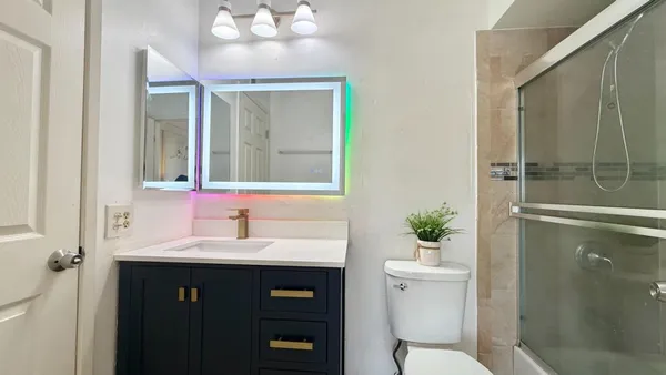 a bathroom with a sink vanity mirror and toilet