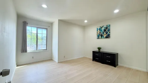 an empty room with windows and cabinet