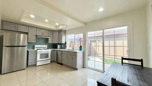 a kitchen with a refrigerator and wooden floor