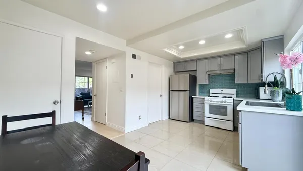 a kitchen with stainless steel appliances kitchen island granite countertop a refrigerator and a stove top oven