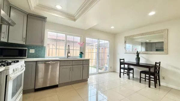 a kitchen with stainless steel appliances granite countertop a stove a sink a dining table and chairs