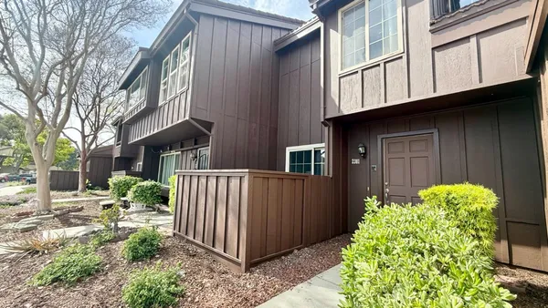 a view of a house with a yard and pathway