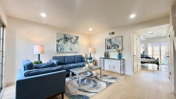 a living room with furniture and wooden floor