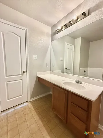 a bathroom with a double vanity sink a mirror and a bathtub
