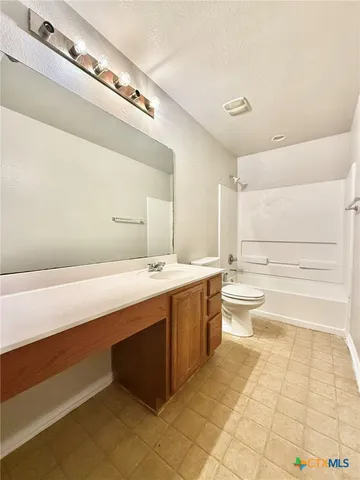 a spacious bathroom with a granite countertop sink a toilet and bathtub