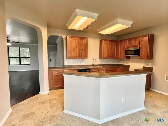 a kitchen with stainless steel appliances granite countertop a stove a sink and a refrigerator