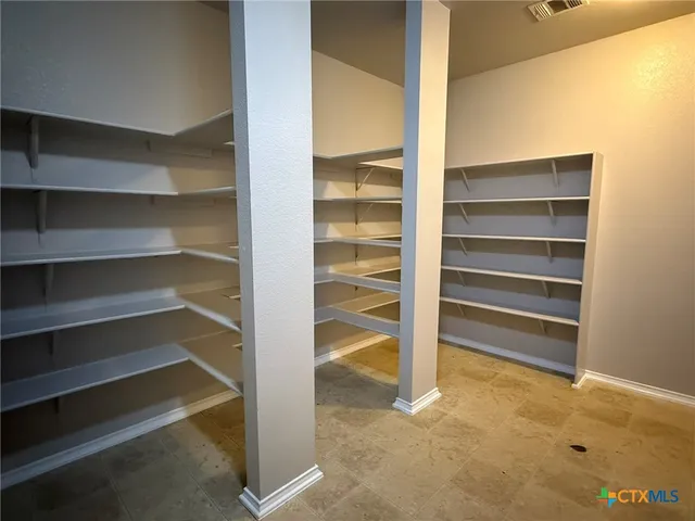 a view of walk in closet with empty racks
