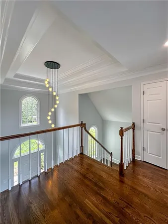 a view of staircase with a large window and wooden floor