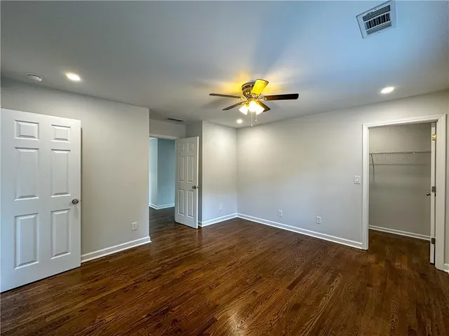 an empty room with wooden floor and chandelier